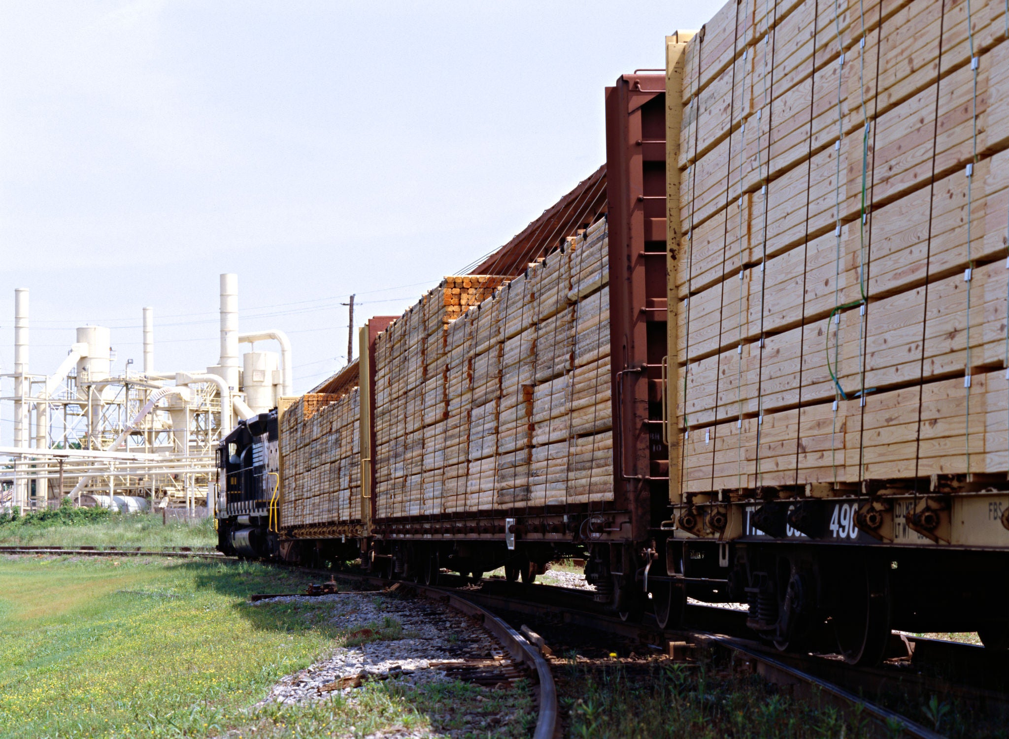 Lumber on centerbeam flat cars on the way to facility.