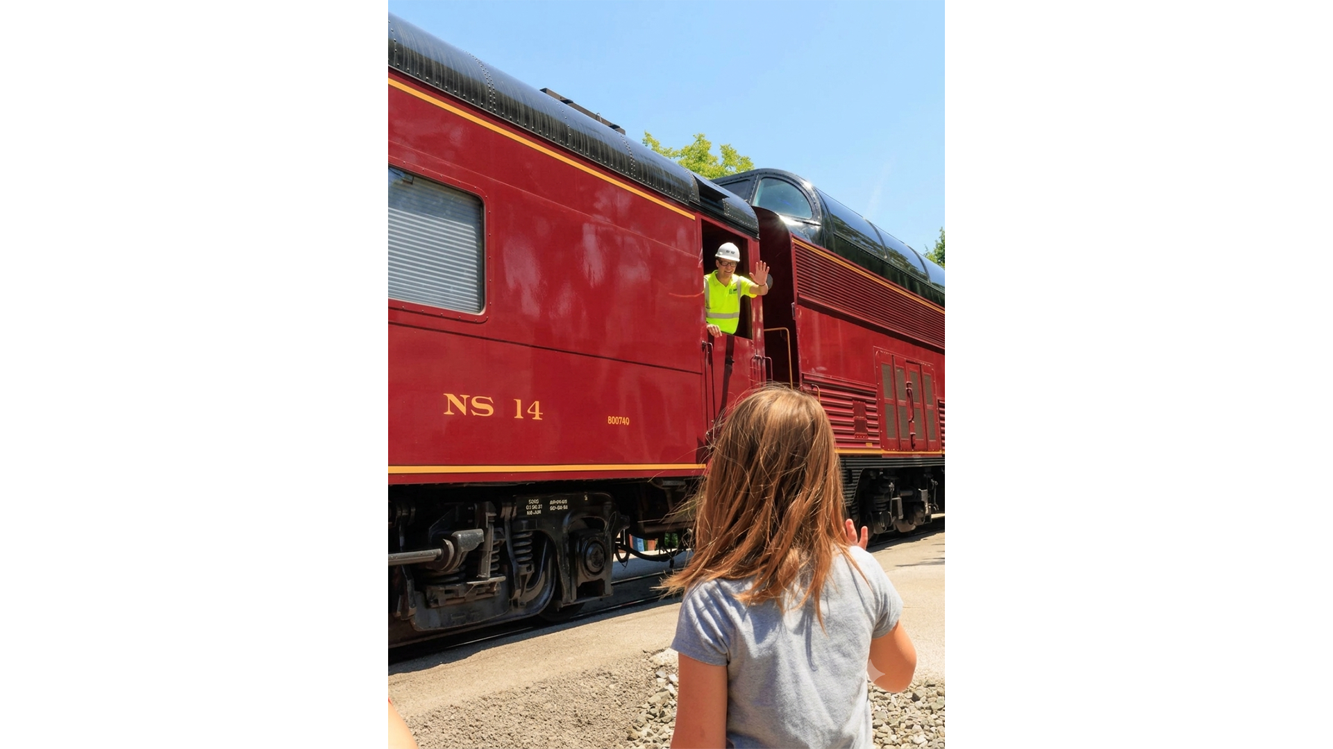 Brian on train while child waves from foreground
